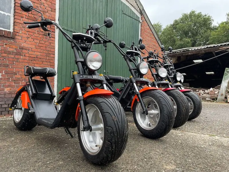 E-choppers van E-verhuur Koldeweij op een rij naast een schuur